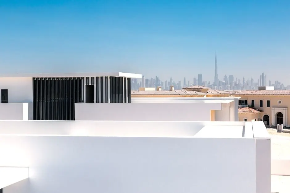 Minimalist architecture with a view of the iconic Dubai skyline in the distance.